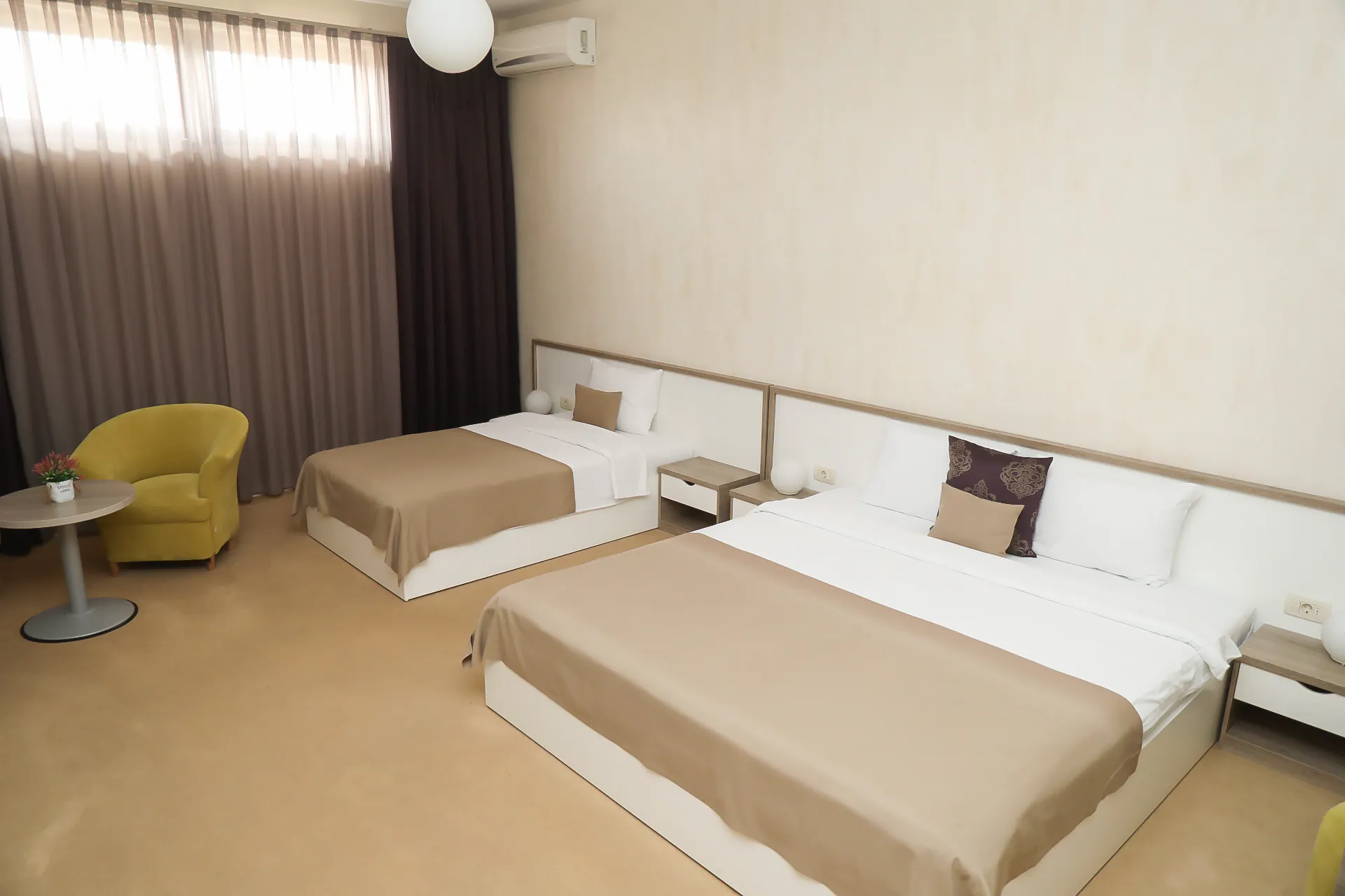 The Deluxe Triple Room at Coconut, with three beds and an armchair