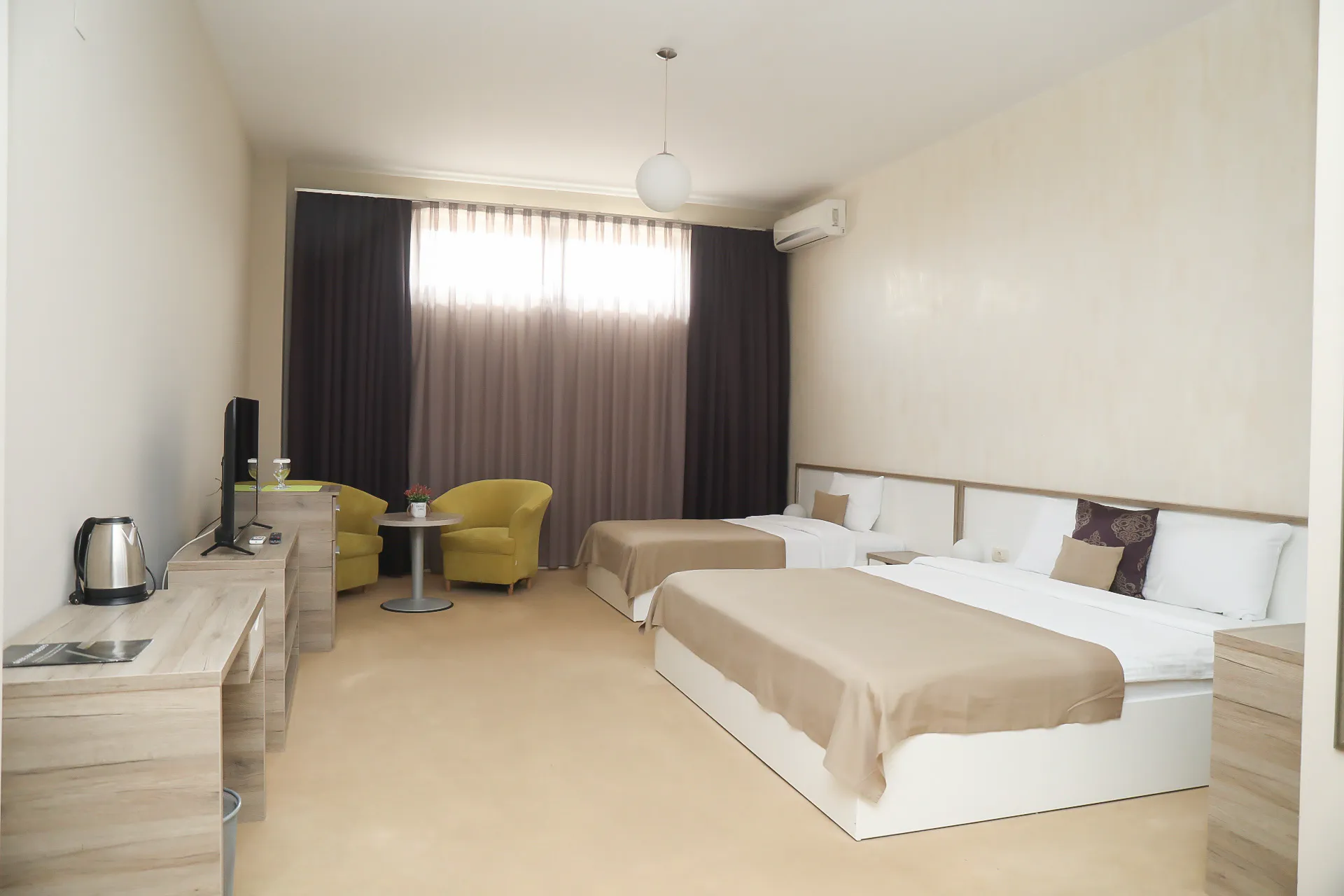 The Deluxe Triple Room at Coconut, with three beds and an armchair
