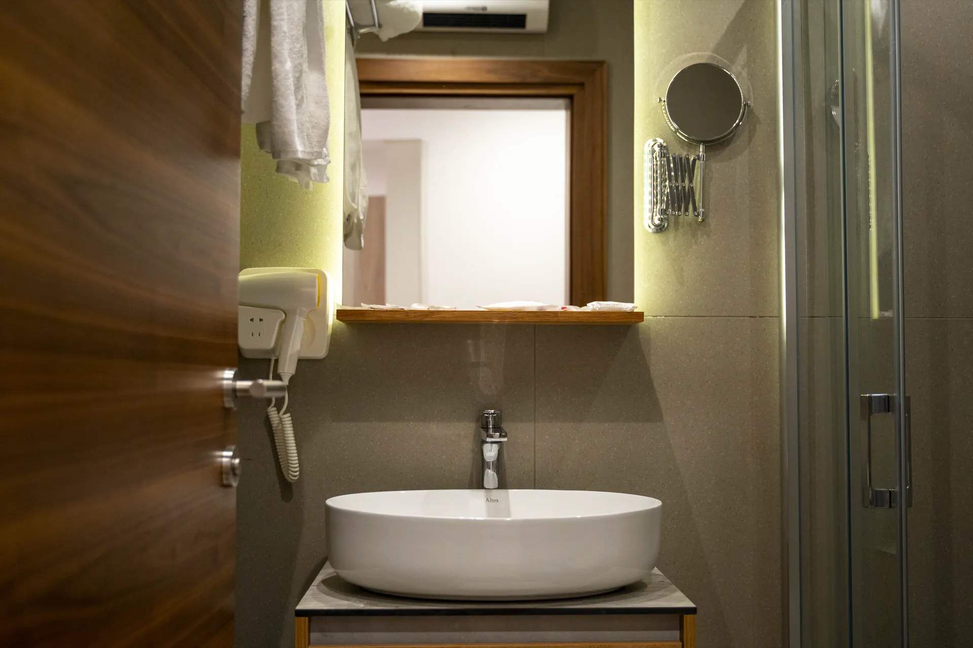 A basin, mirror and shower in a Coconut bathroom